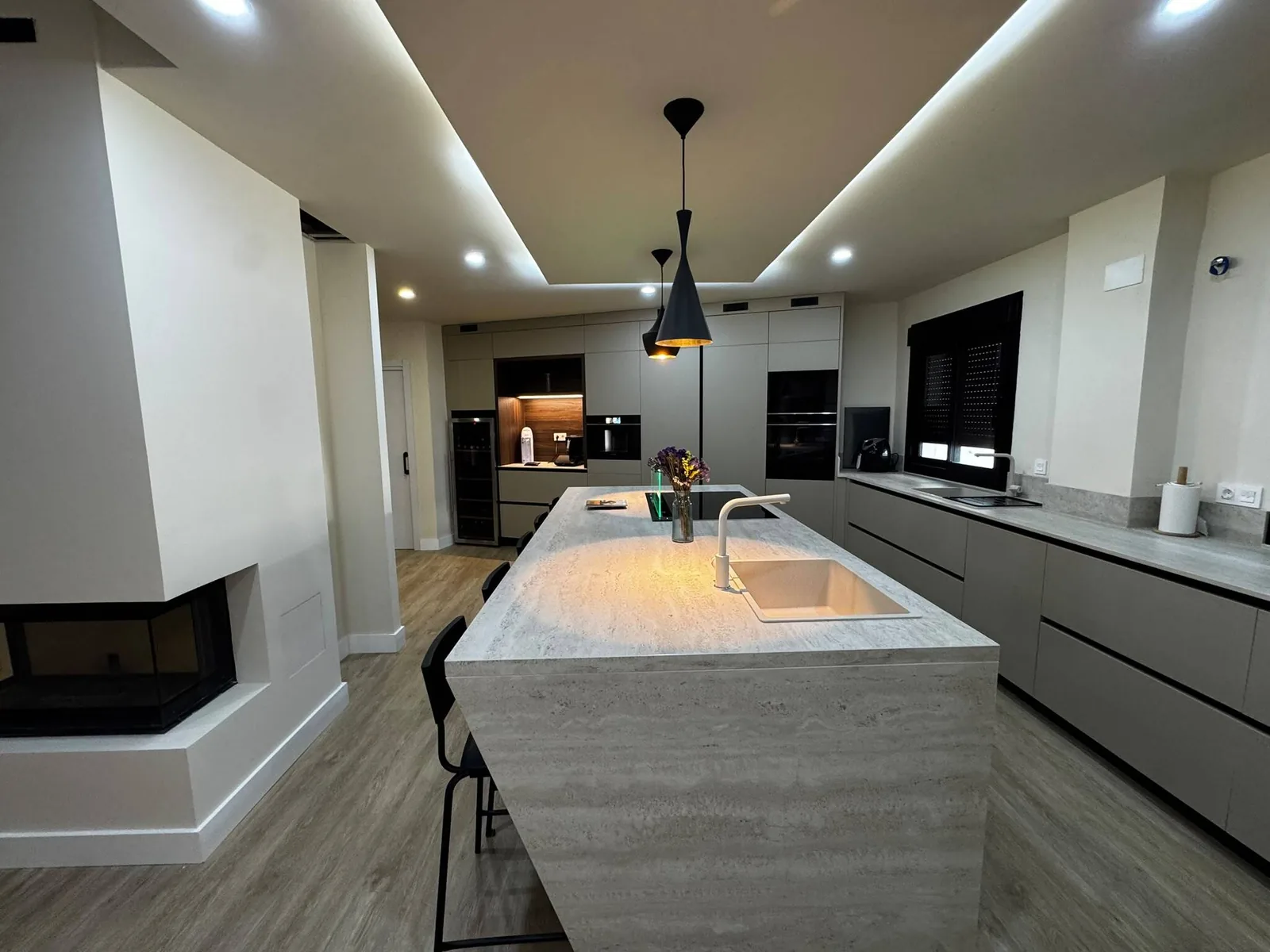 Cocina con isla y mobiliario integrado en tonos grises